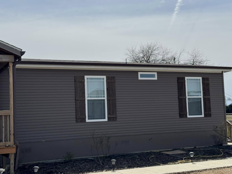 gutter-repair-on-outer-wall-of-mobile-home-with-windows