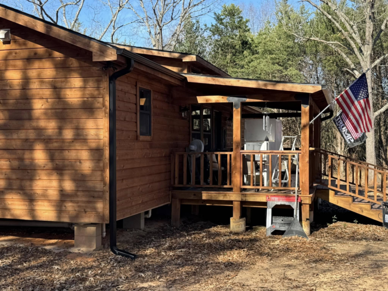 gutter-repair-on-wooden-house-with-flag-and-deck-area