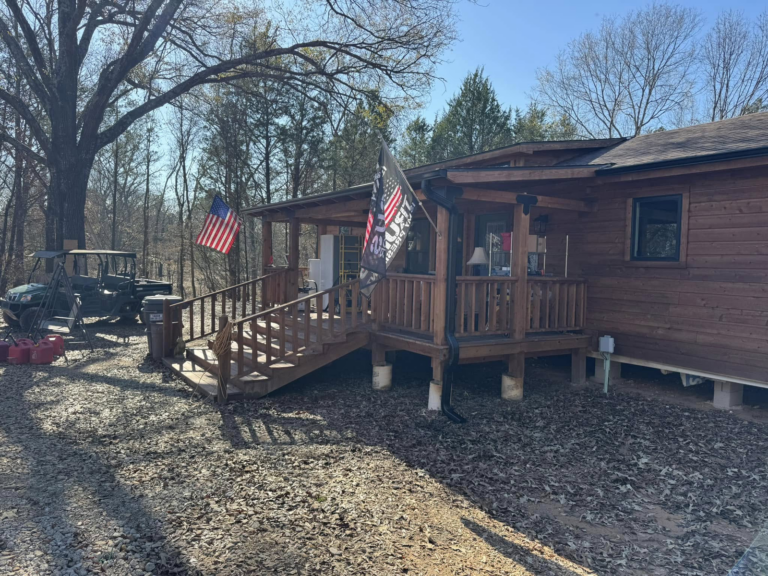 seamless-gutter-installation-on-log-cabin-with-porch-and-flags